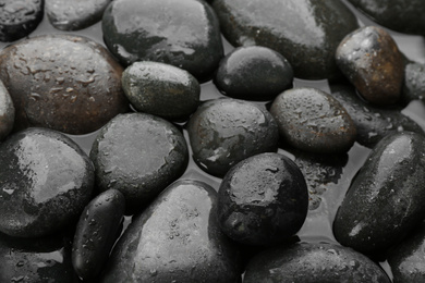 Photo of Spa stones in water as background, closeup. Zen lifestyle