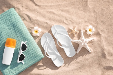 Flat lay composition with beach accessories on sand