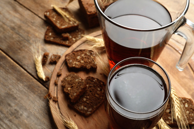 Delicious kvass, bread and spikes on wooden table. Space for text