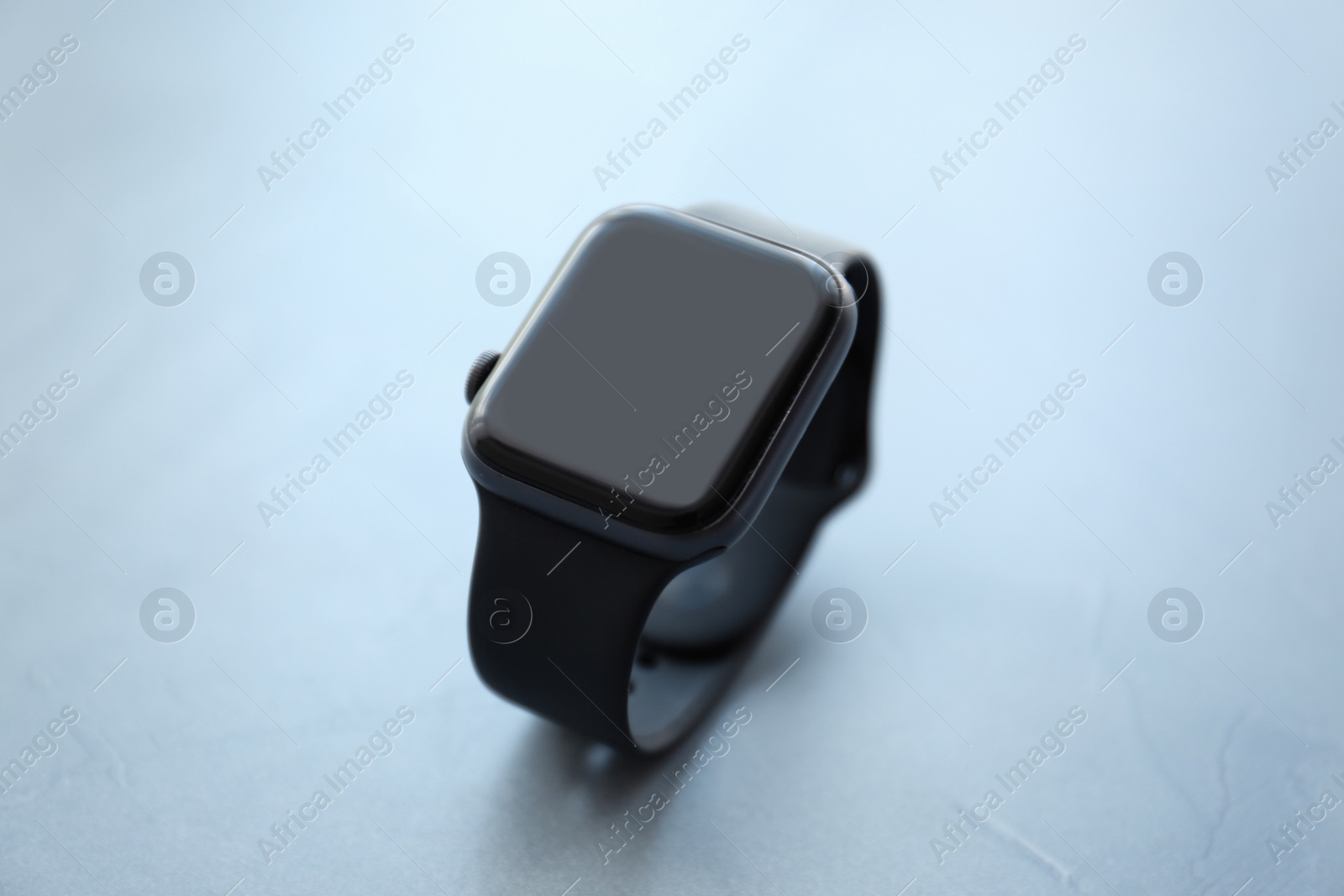 Stylish smart watch on grey stone table, closeup Photo of Stylish smart watch on grey stone table, closeup