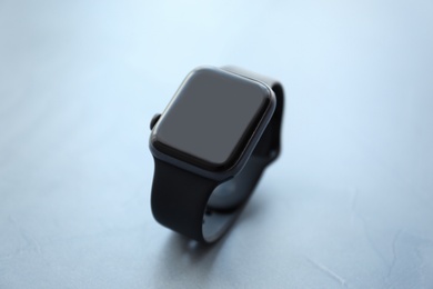 Photo of Stylish smart watch on grey stone table, closeup