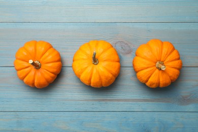 Photo of Fresh ripe pumpkins on turquoise wooden table, flat lay