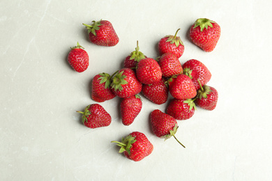 Delicious ripe strawberries on light grey marble table, flat lay