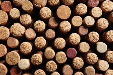 Photo of Many corks of wine bottles as background, top view