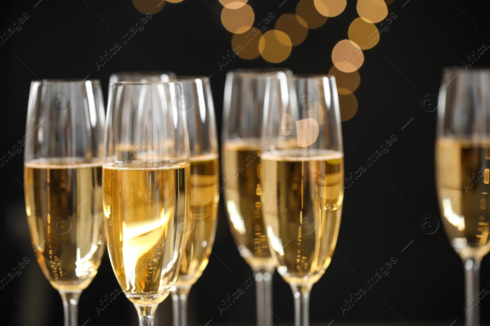 Photo of Glasses of champagne on blurred background, closeup. Space for text