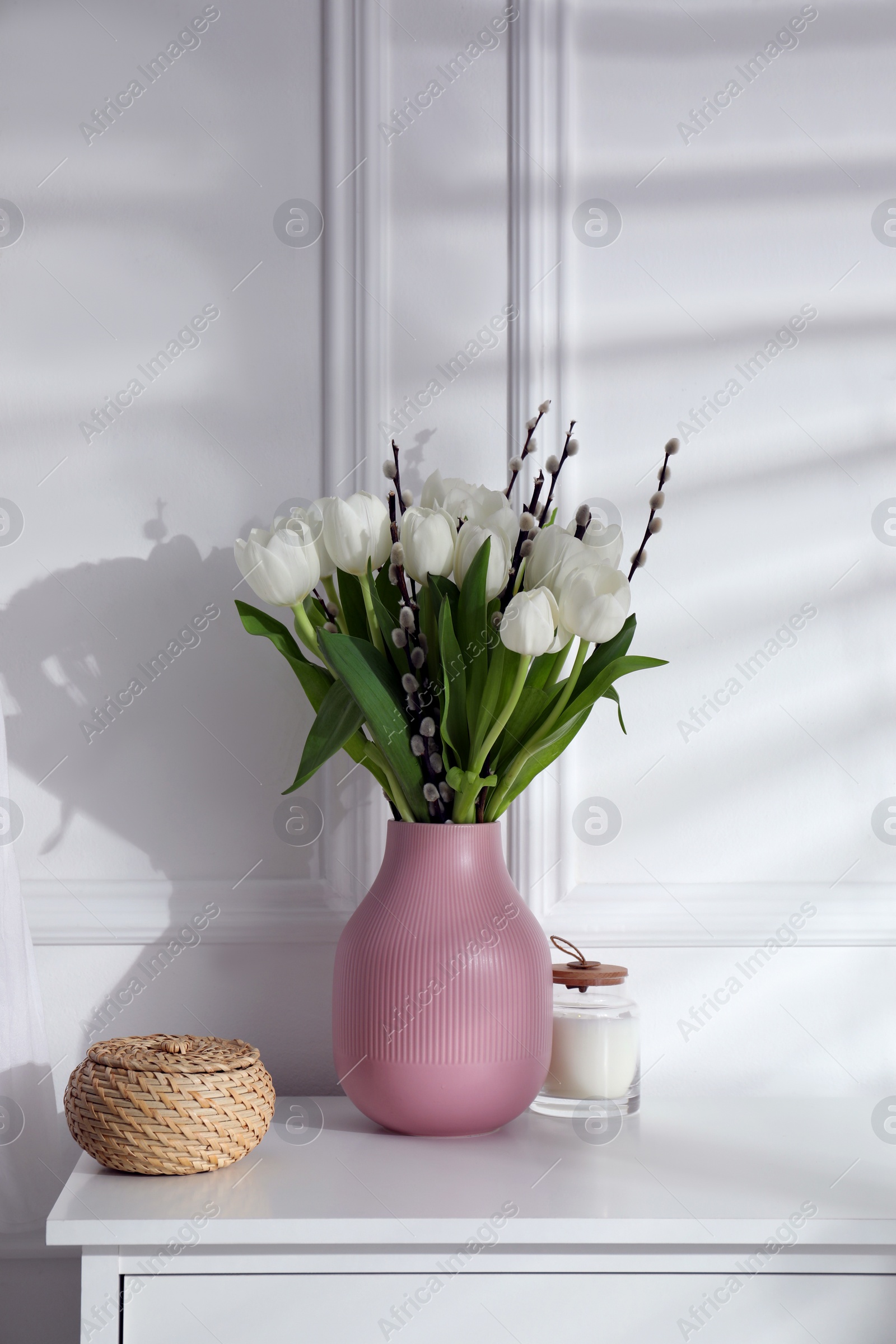 Photo of Beautiful bouquet of willow branches and tulips in vase indoors