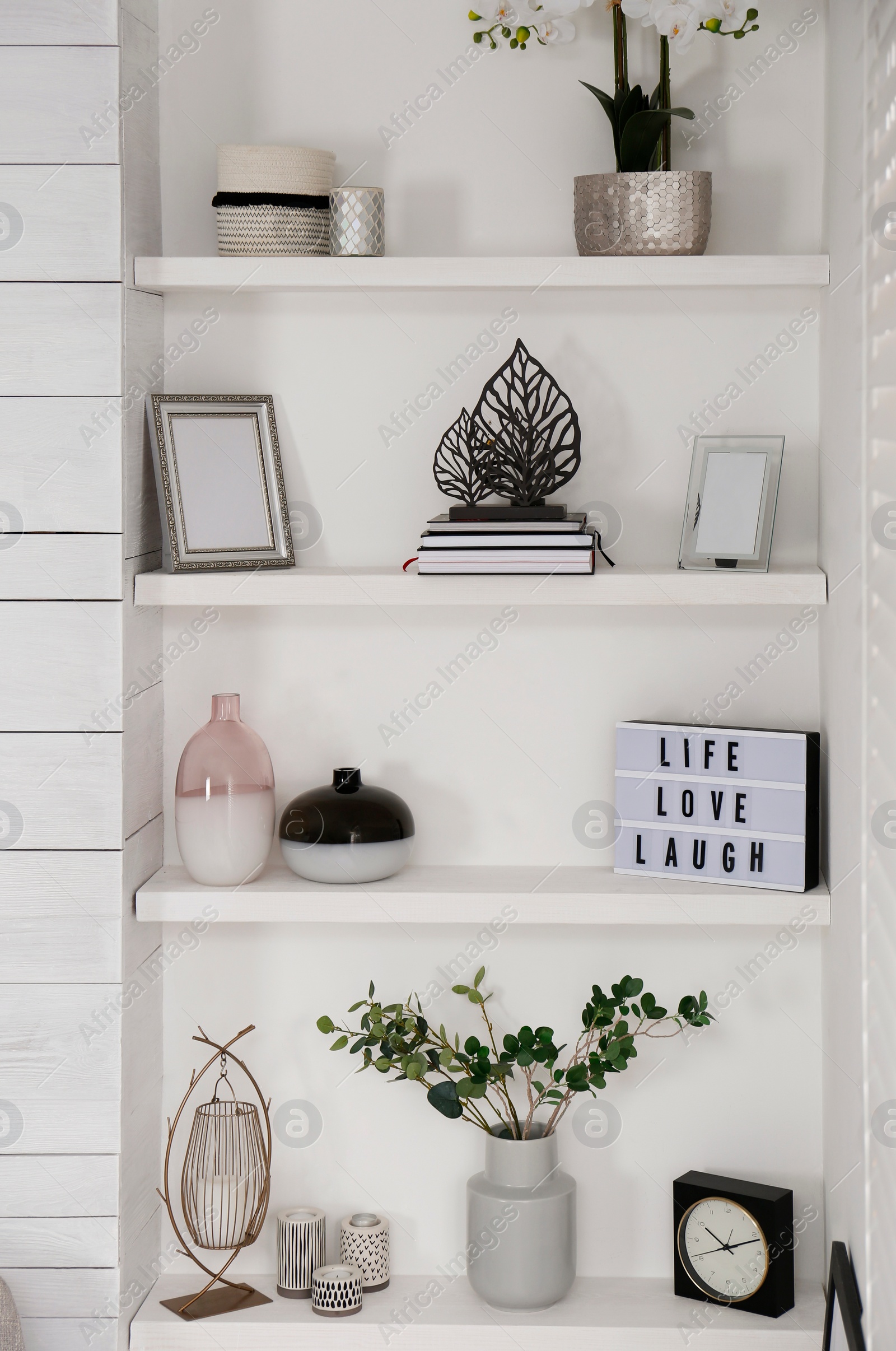 Photo of Wall shelves with beautiful decor elements indoors. Interior design