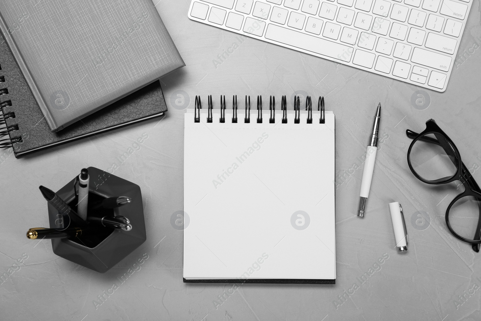 Photo of Flat lay composition with notebooks and glasses on light grey table