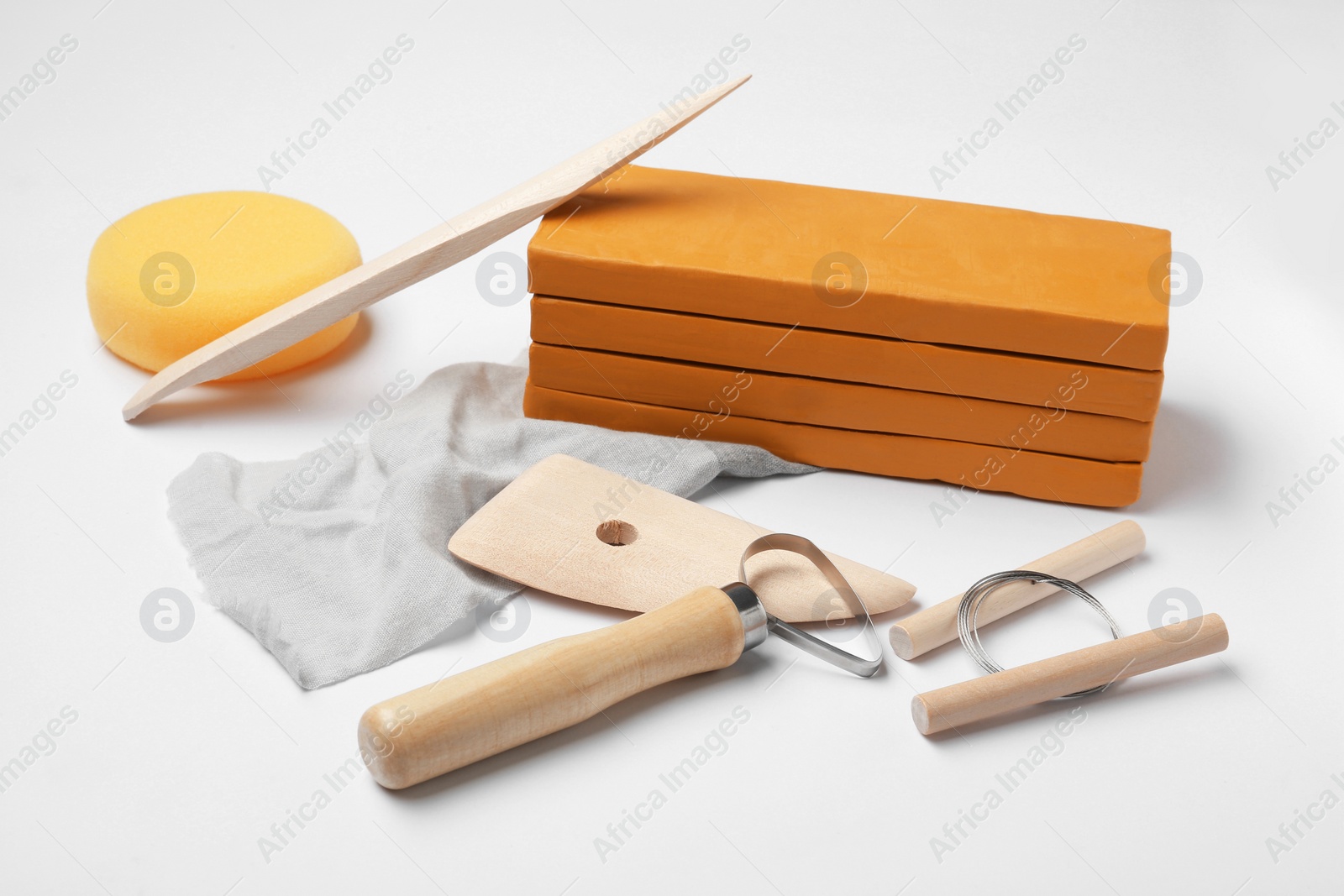 Photo of Clay and different modeling tools on white background