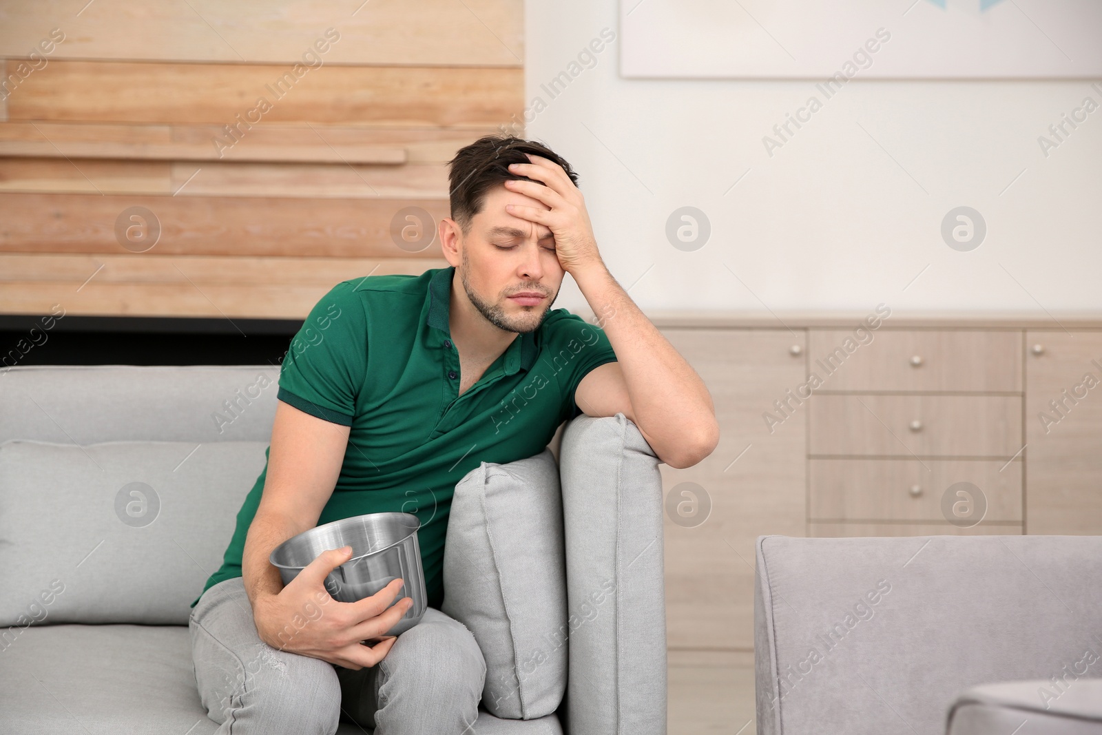 Photo of Young man having nausea at home. Space for text