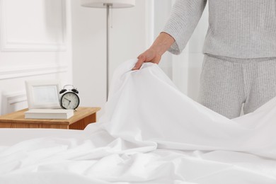 Woman changing bed linens at home, closeup. Space for text
