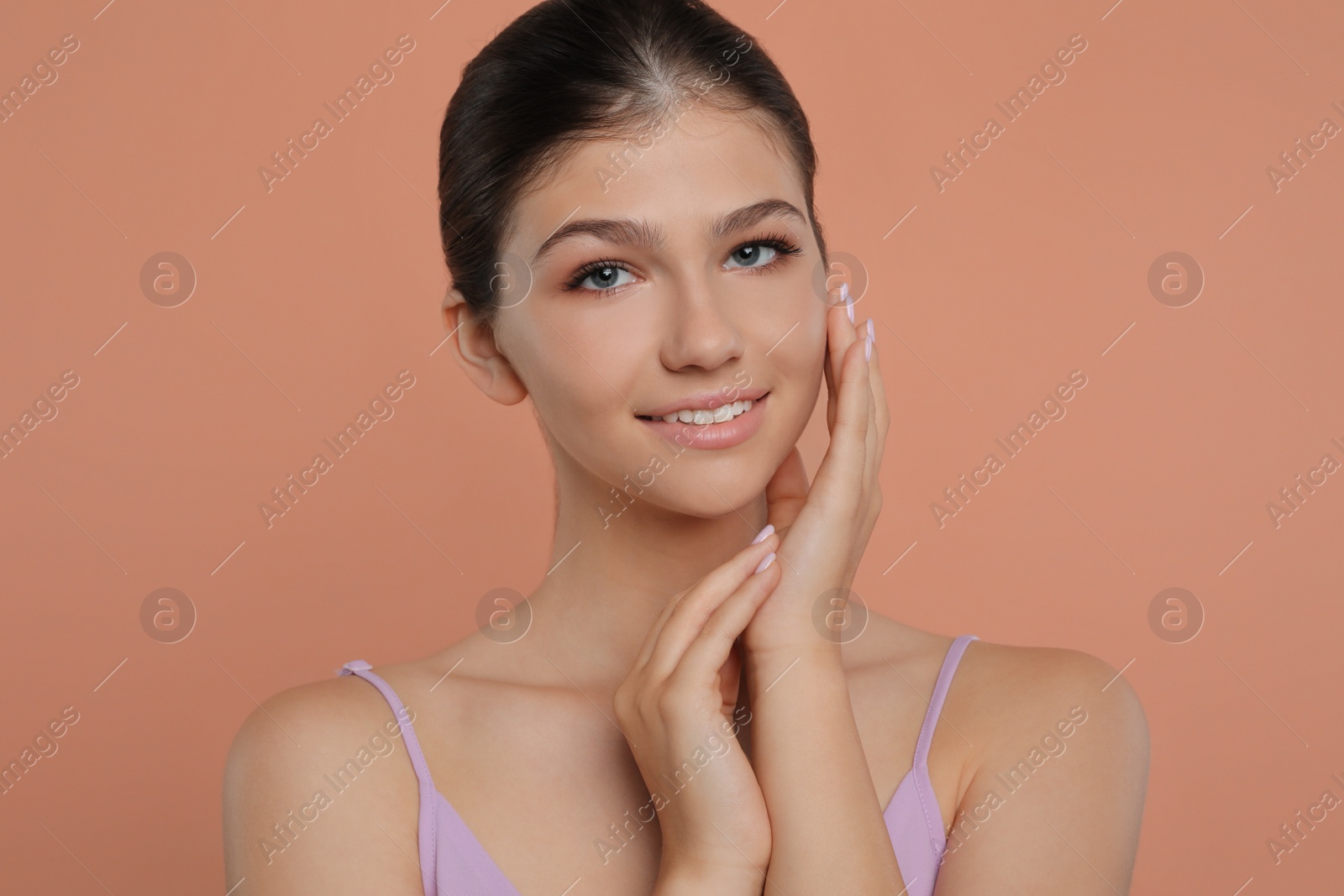 Photo of Portrait of pretty girl on pale coral background. Beautiful face with perfect smooth skin