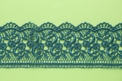 Photo of Beautiful lace on green background, top view