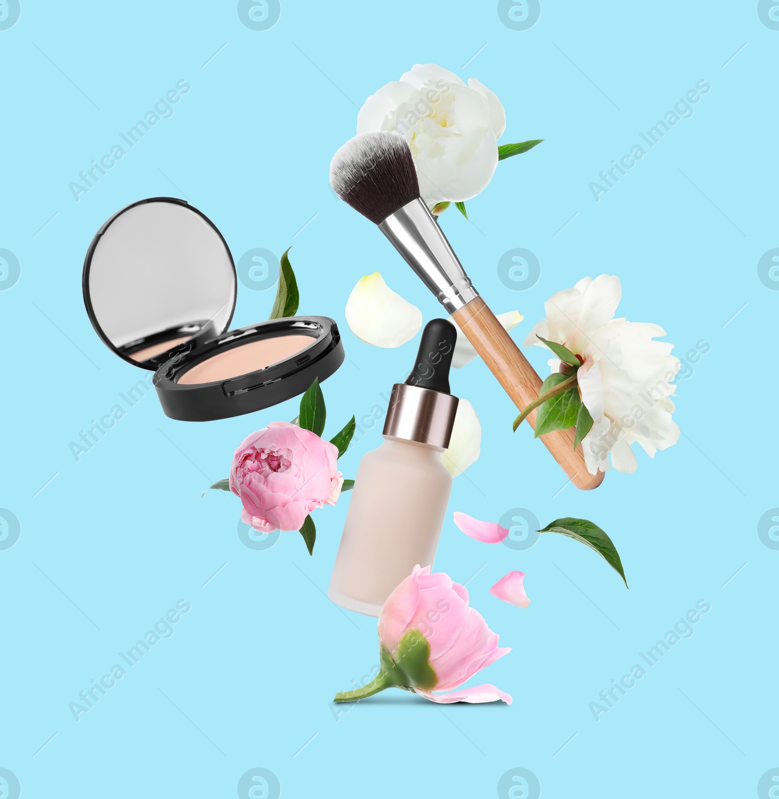 Image of Spring flowers and makeup products in air on light blue background