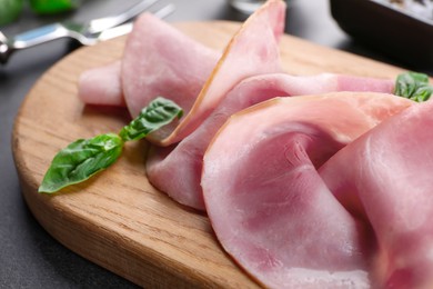 Photo of Tasty ham with basil on table, closeup