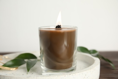 Photo of Burning candle with wooden wick on tray