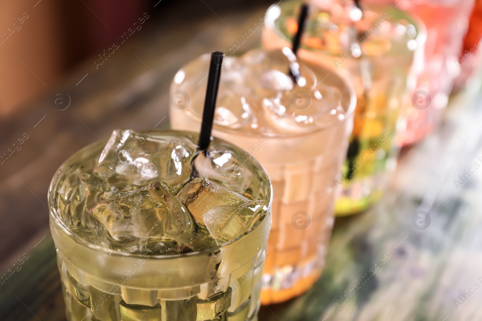 Photo of Glasses of delicious cocktails with ice on table, closeup