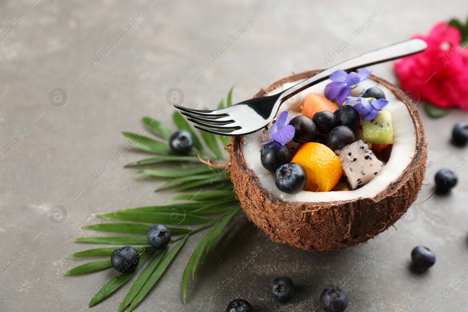 Photo of Delicious exotic fruit salad served on grey table