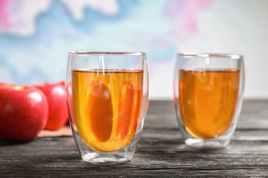 Glasses of apple juice on dark wooden table