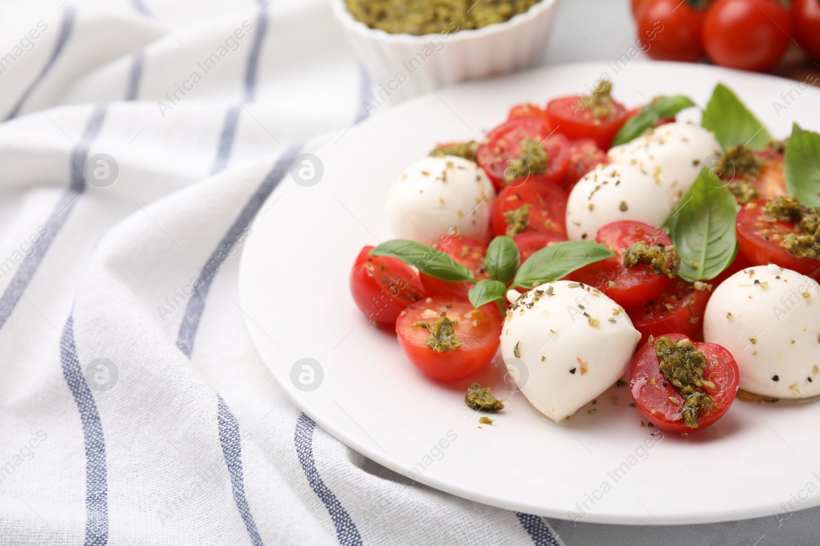 Photo of Tasty salad Caprese with tomatoes, mozzarella balls and basil on table, closeup. Space for text