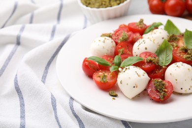 Photo of Tasty salad Caprese with tomatoes, mozzarella balls and basil on table, closeup. Space for text