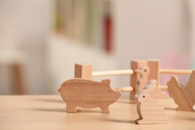 Wooden animals and fence on table, closeup. Space for text. Children's toys