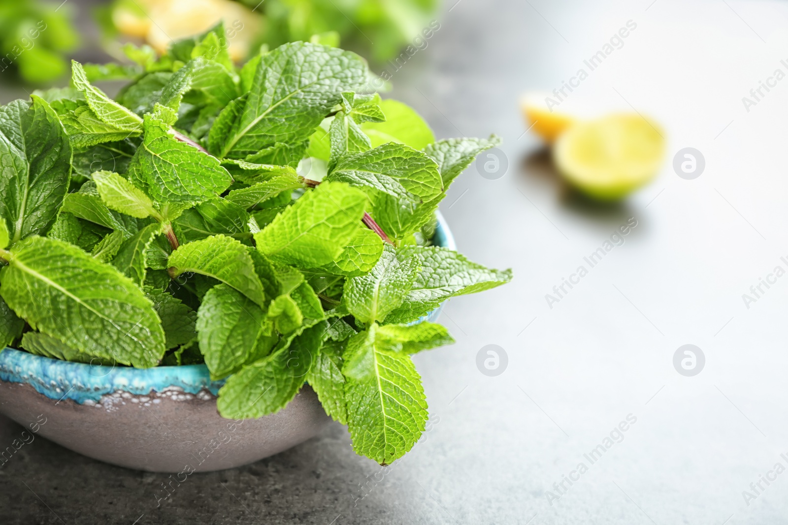 Photo of Bowl with fresh aromatic mint on table