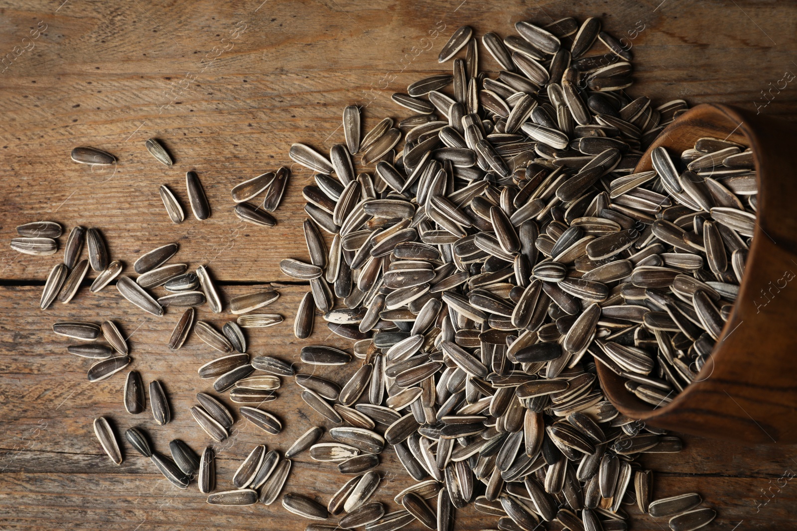 Photo of Organic sunflower seeds on wooden table, flat lay