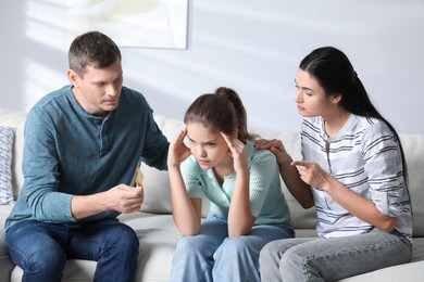 Photo of Parents talking with their teenage daughter about contraception at home. Sex education concept