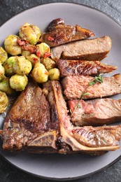 Delicious fried beef meat, vegetables and thyme on table, top view