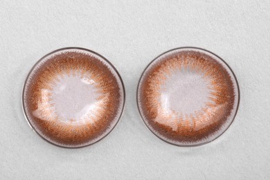Photo of Two color contact lenses on white background, top view