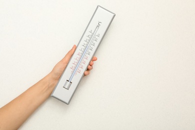 Photo of Woman with weather thermometer on white background, closeup. Space for text