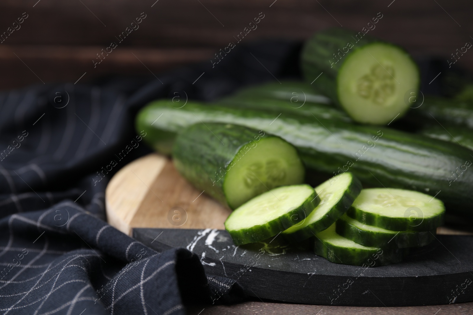 Photo of Fresh whole and cut cucumbers on table, closeup