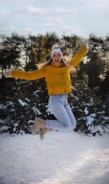 Cheerful woman enjoying winter day in forest