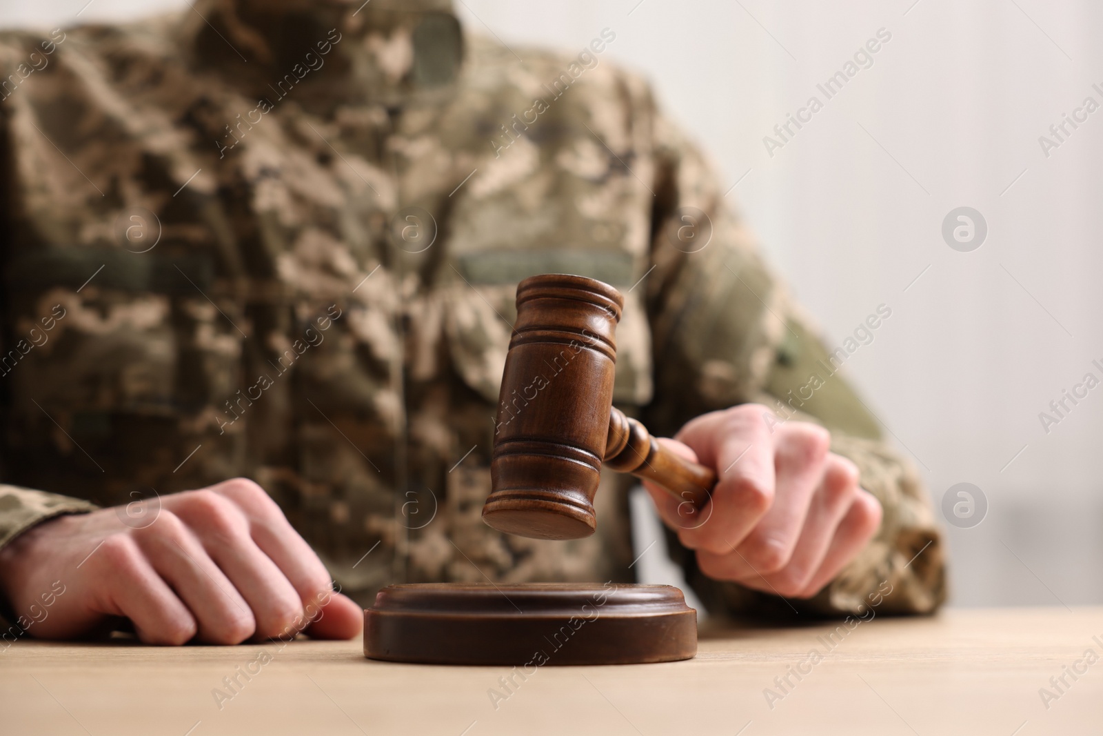 Photo of Law concept. Man in military uniform with gavel at table, closeup. Space for text