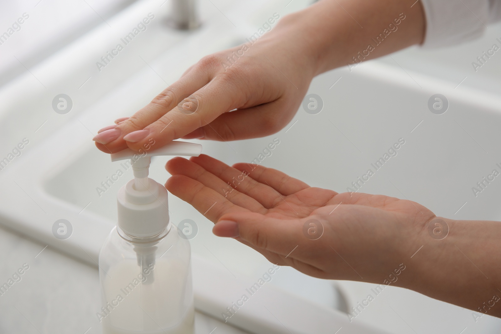 Photo of Woman washing hands with liquid soap at home, closeup