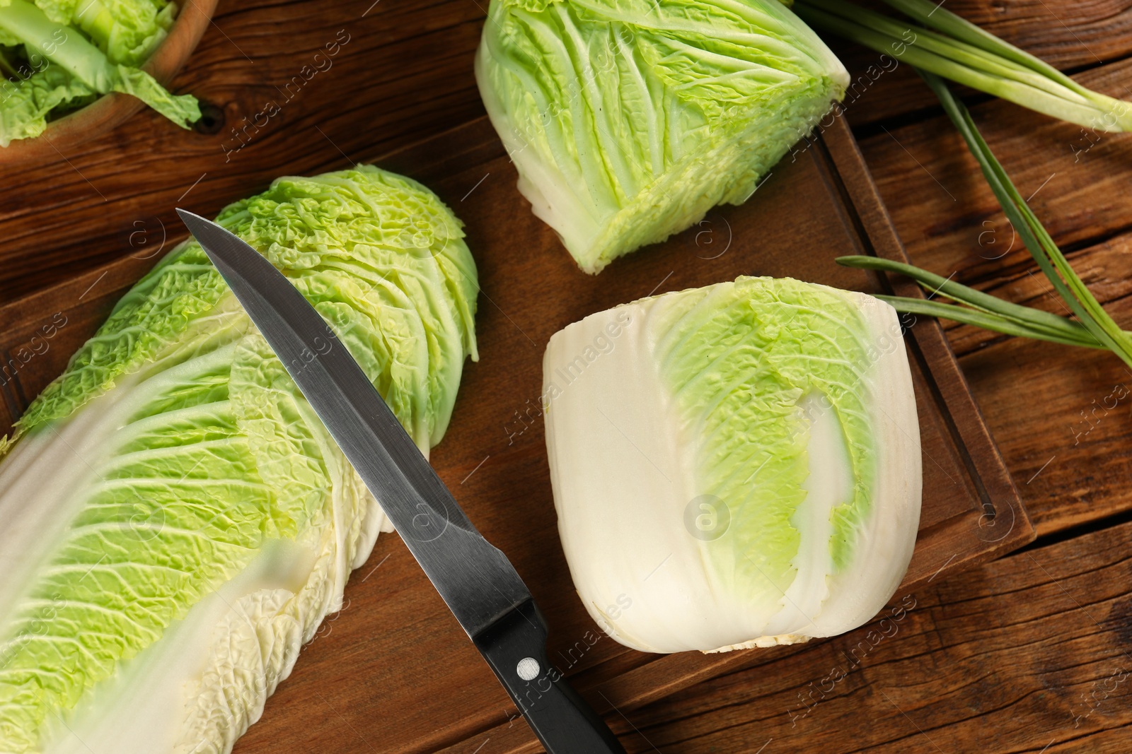 Photo of Whole and cut fresh Chinese cabbages on wooden table, flat lay