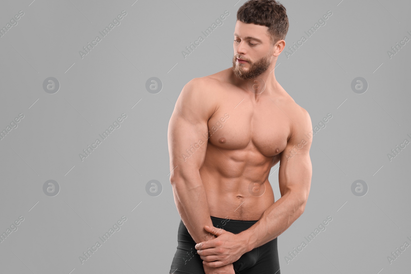 Photo of Handsome muscular man on light grey background, space for text. Sexy body