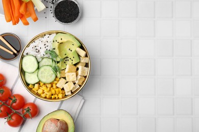 Photo of Delicious poke bowl and ingredients on white tiled table, flat lay. Space for text