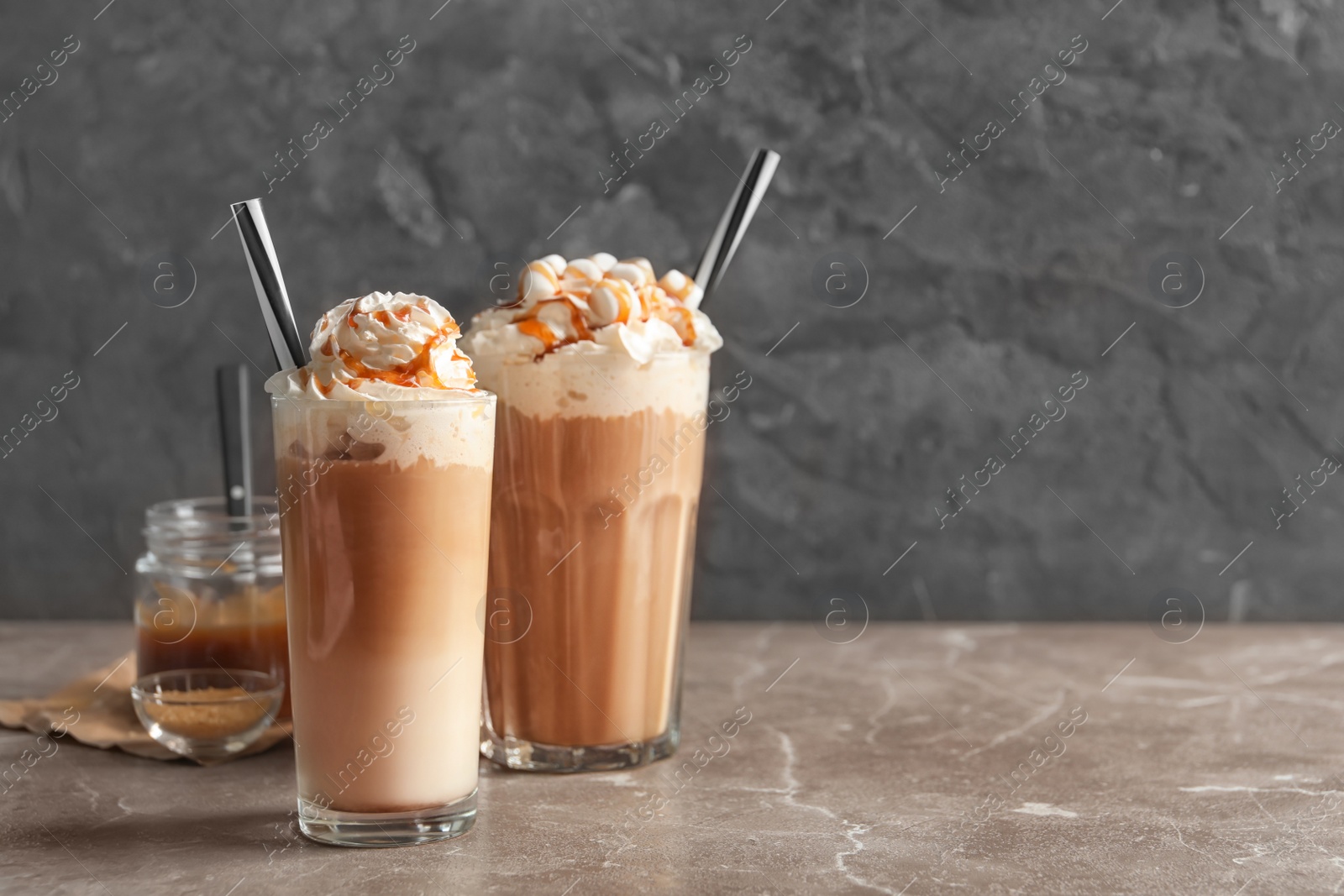 Photo of Glasses with delicious caramel frappe on table