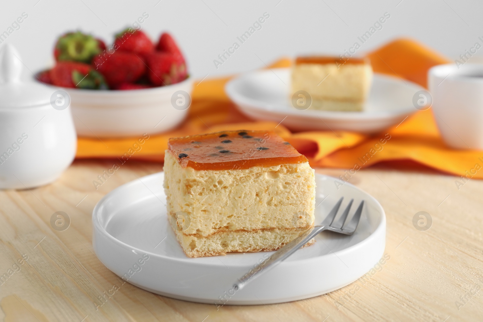 Photo of Piece of cheesecake with jelly and fork on wooden table