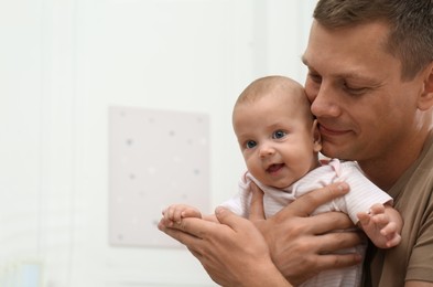 Photo of Happy father with his little baby at home. Space for text