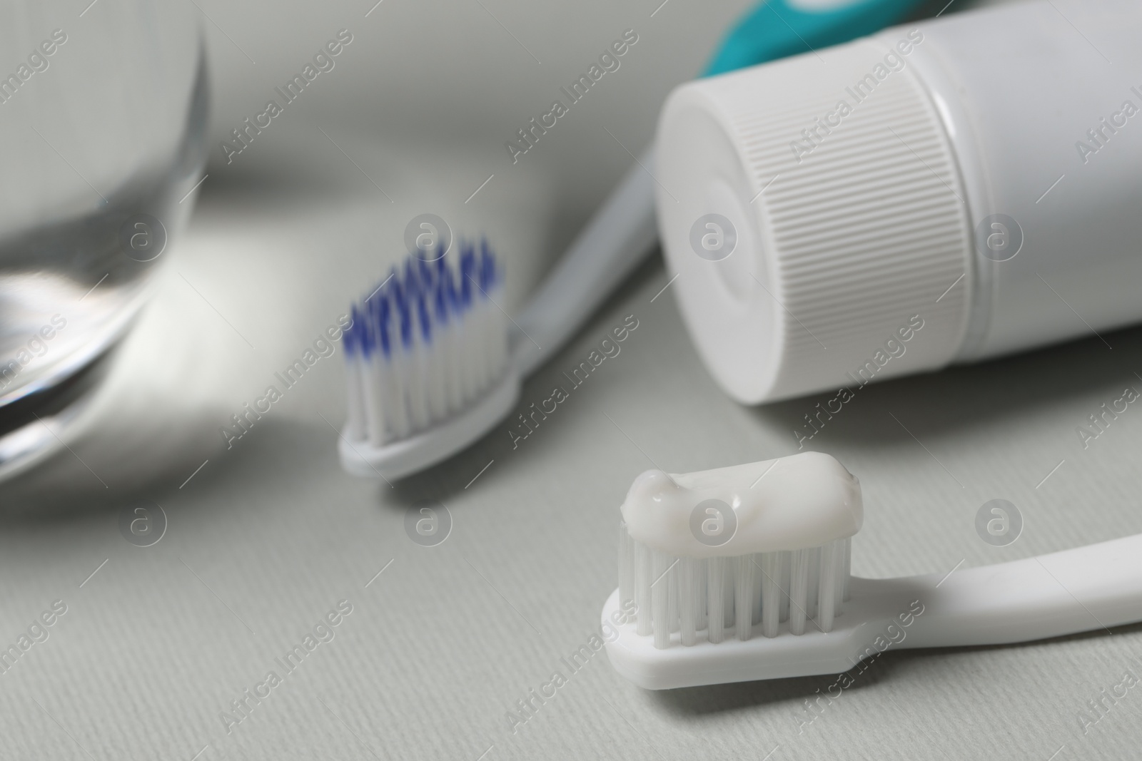 Photo of Plastic toothbrush with paste on grey background, closeup