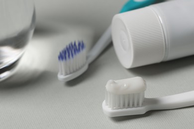 Plastic toothbrush with paste on grey background, closeup