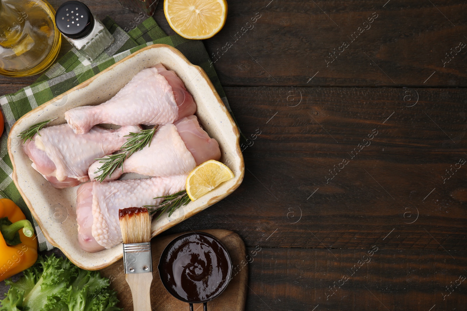 Photo of Flat lay composition with marinade and raw chicken drumsticks on wooden table. Space for text