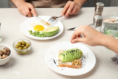 Photo of Women having breakfast with avocado at table