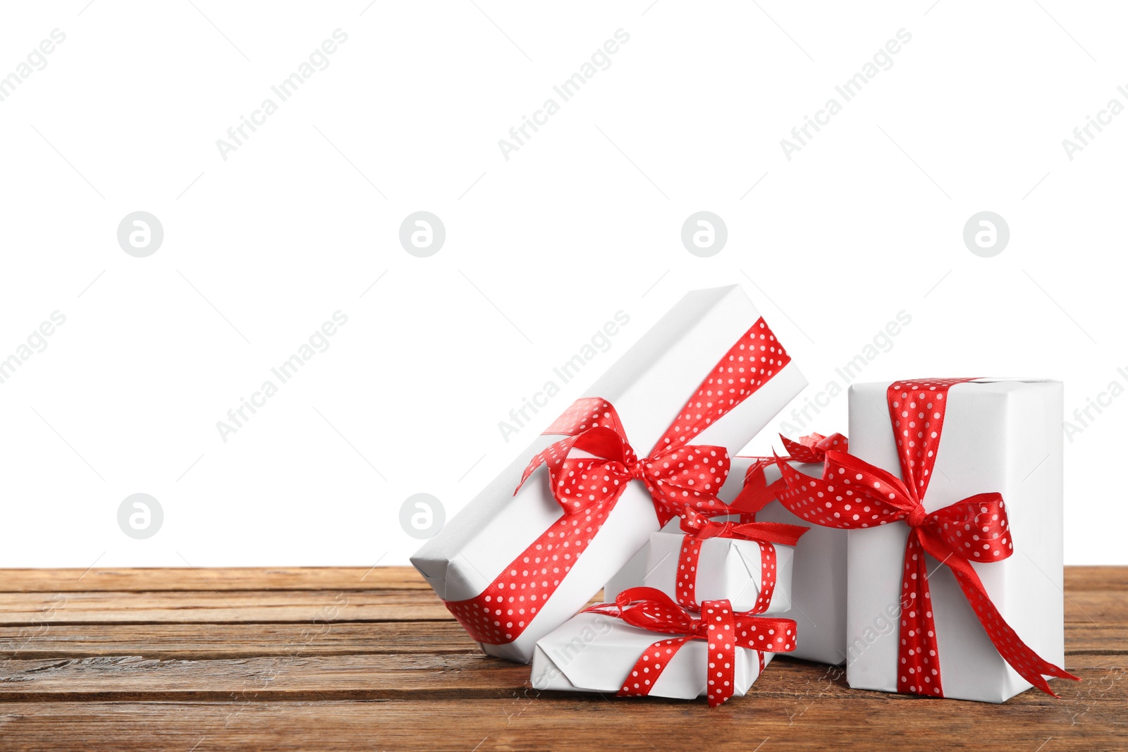 Photo of Many Christmas gifts on wooden table against white background. Space for text