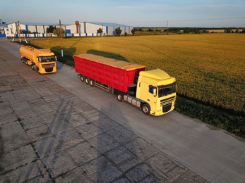 Photo of Modern bright trucks parked on country road