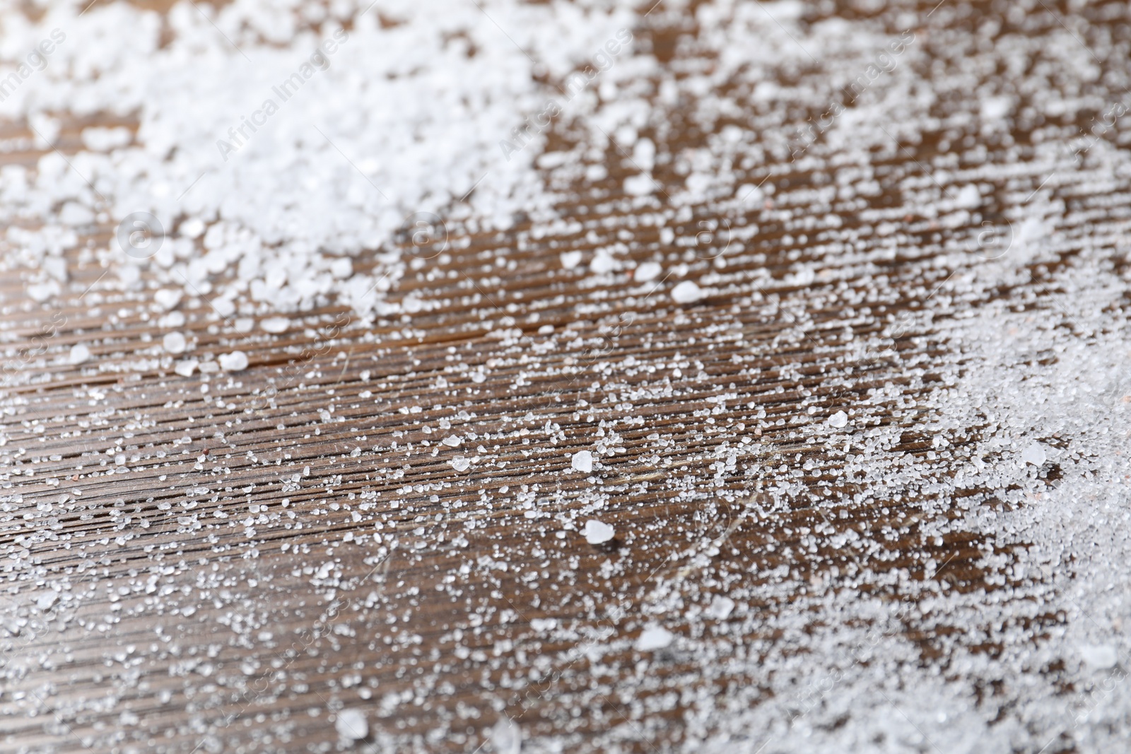 Photo of Organic white salt on wooden table, closeup