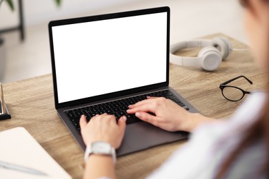 Photo of Woman watching webinar at wooden table in office, closeup